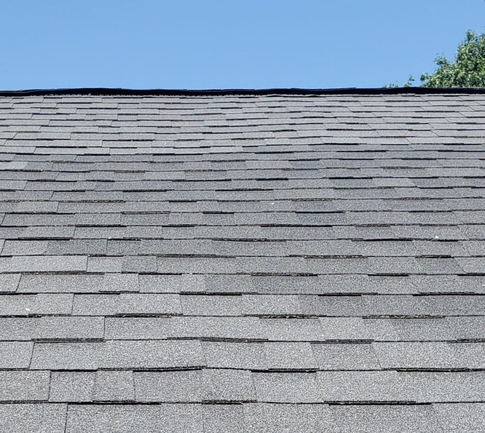 A shingle roof slope with softened, uneven colour